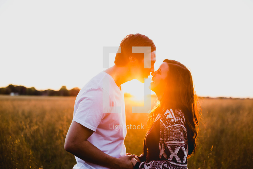 couple in a field at sunset 