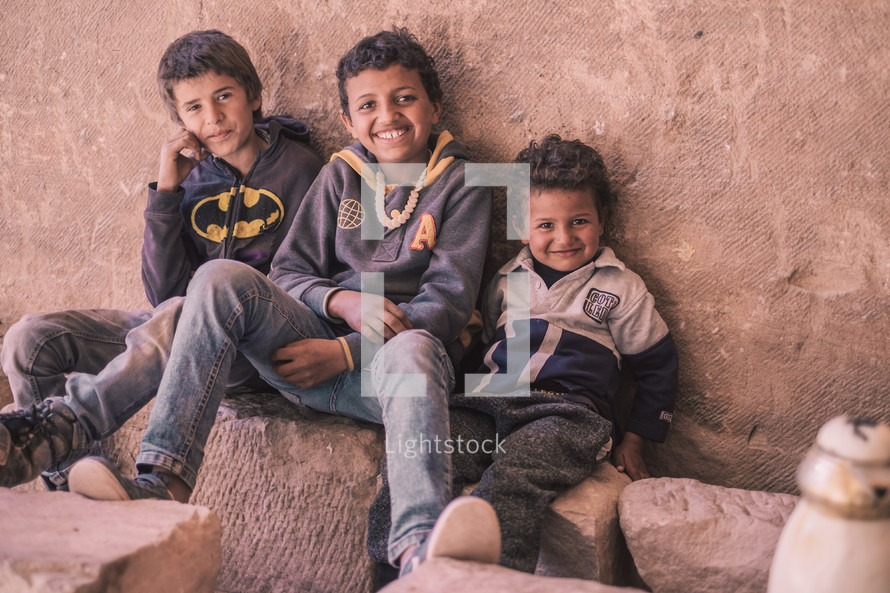 young boys sitting on rocks 