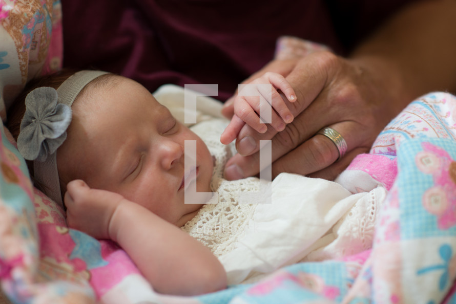 father holding a newborn's hand 