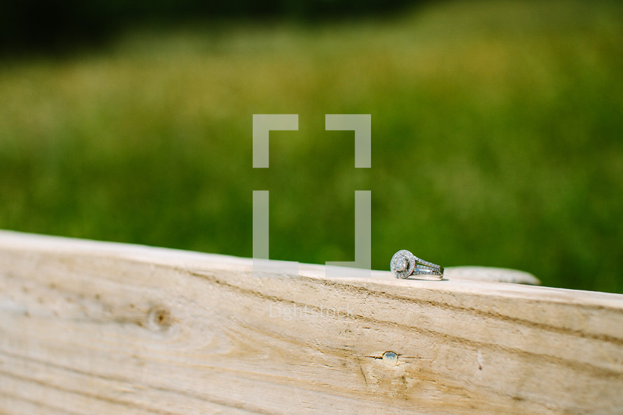 engagement ring on wood railing 
