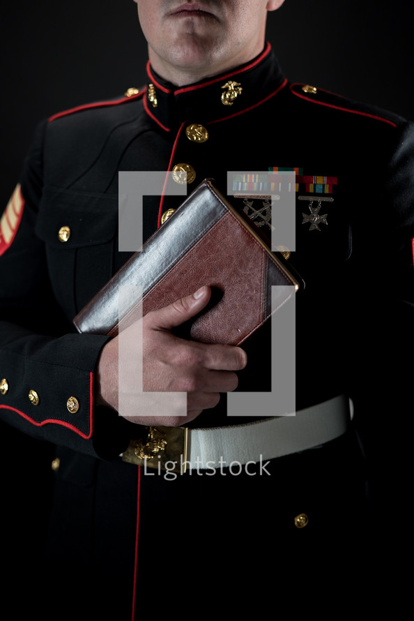 Marine holding a Bible against his chest 