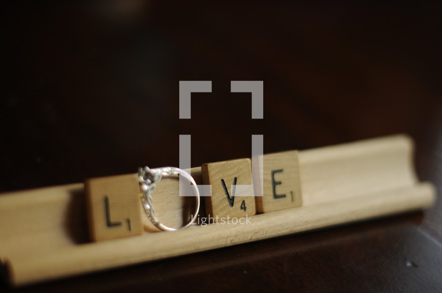 word Love out of scrabble pieces and engagement ring