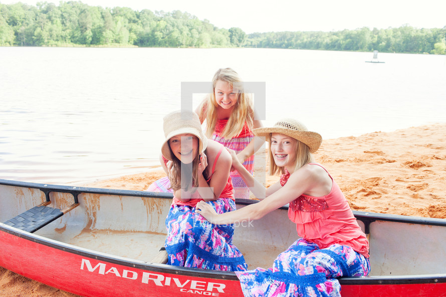 sisters in a canoe on the sand 