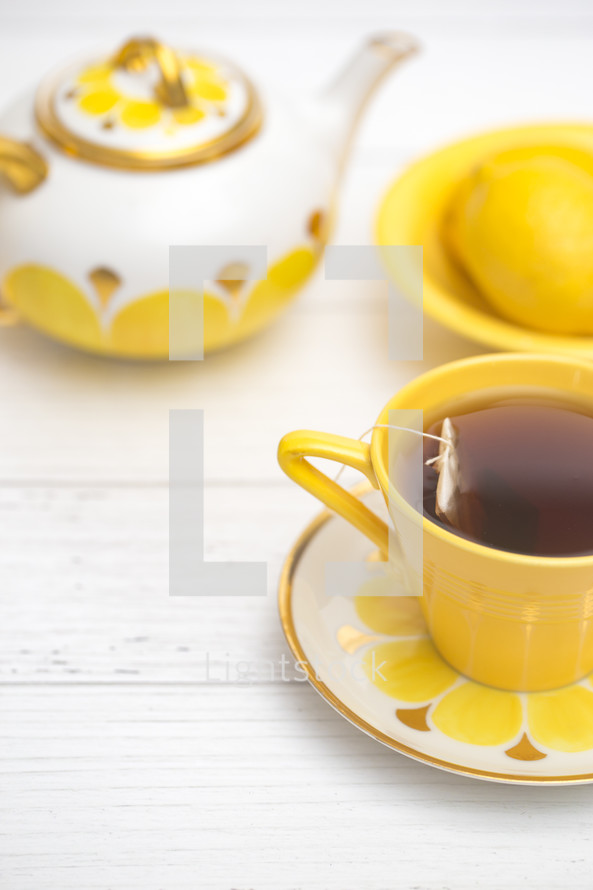 Bright Yellow Tea Set on a White Wood Table