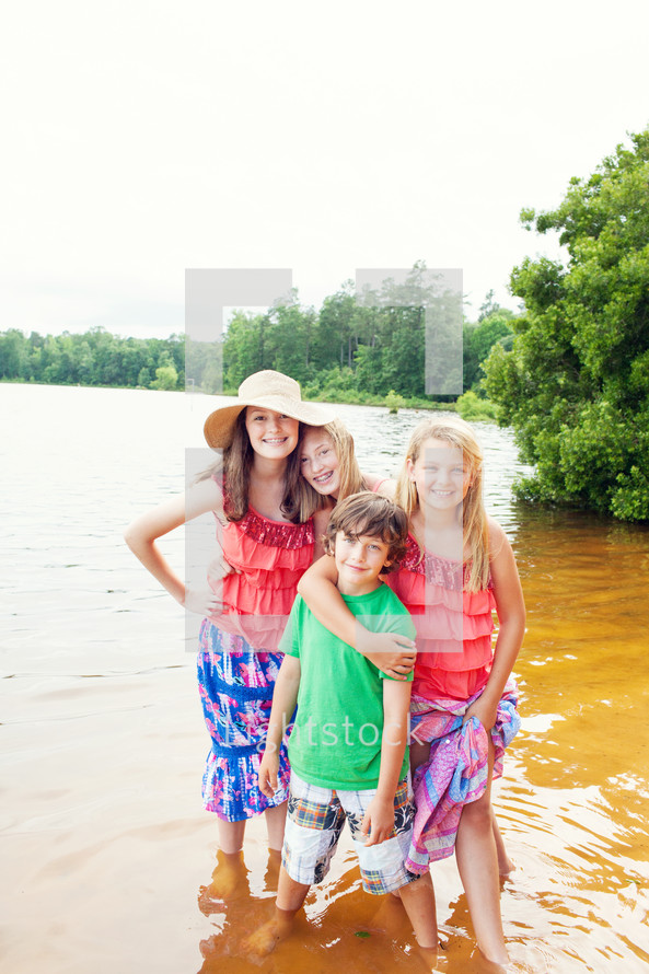 siblings standing in lake water 