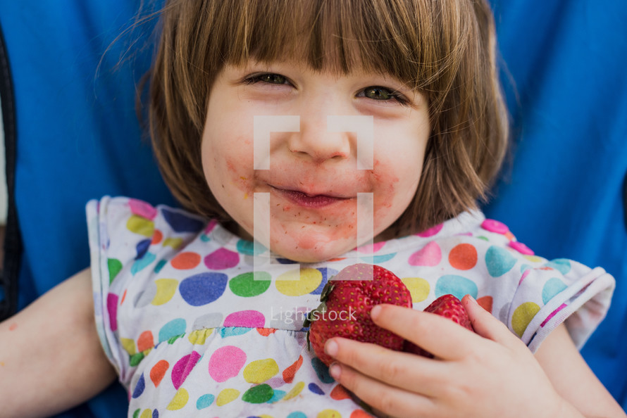 toddler girl eating strawberries 