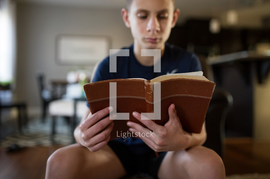 a boy reading a Bible 