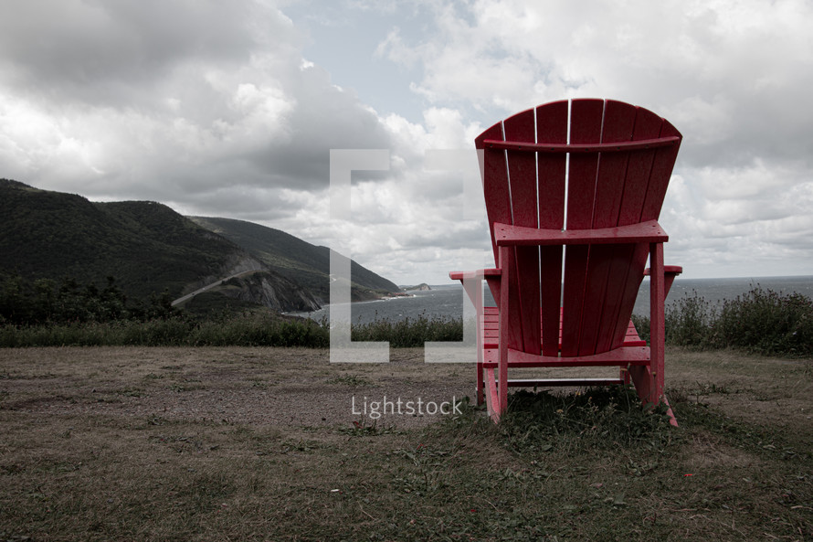 red Adirondack chair on a beach 