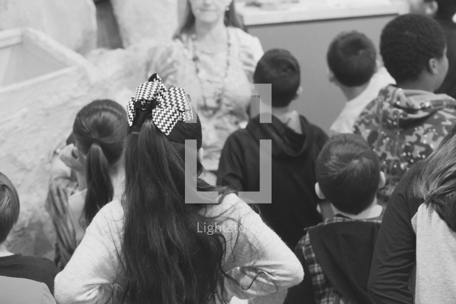 children listening to their teacher in black and white 