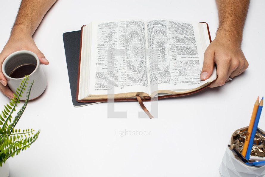 a man reading a Bible at a desk 