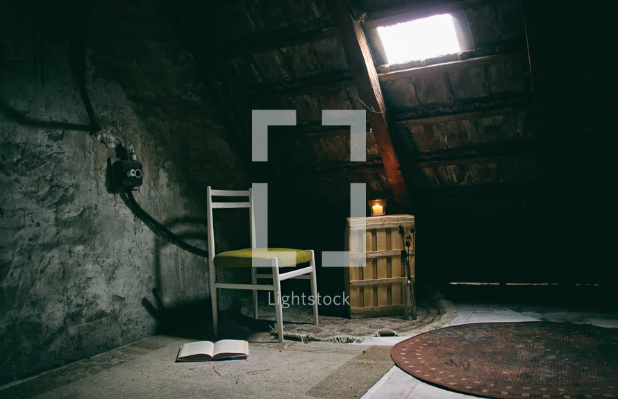 open Bible and chair in an empty attic 