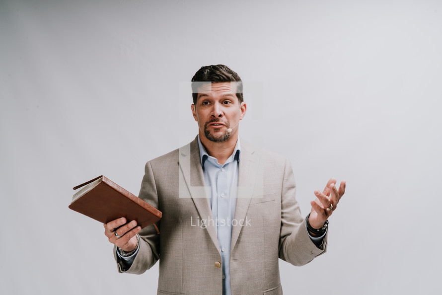 a minister preaching holding a Bible 