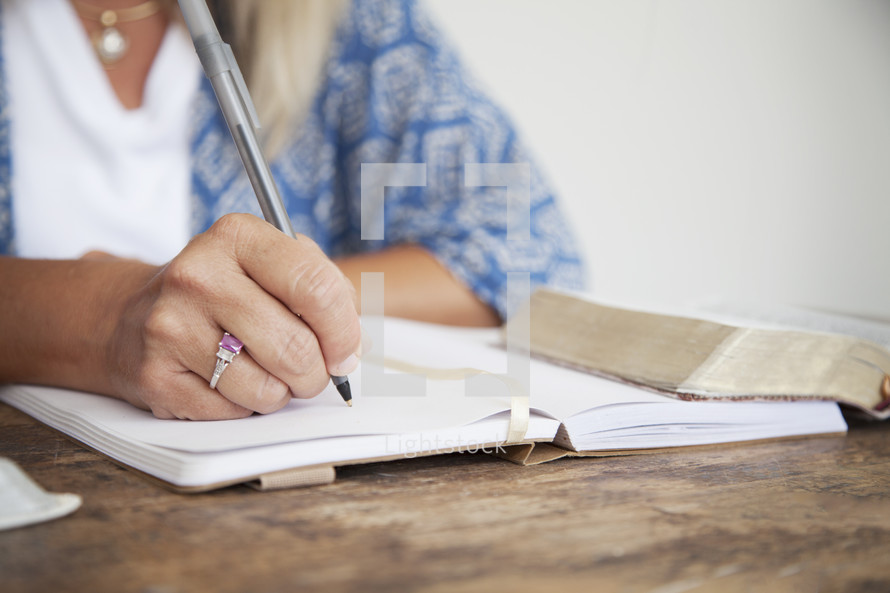 elderly woman writing in a journal at a Bible study 