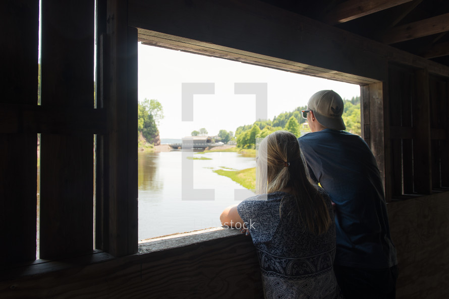 a couple standing on a covered bridge 