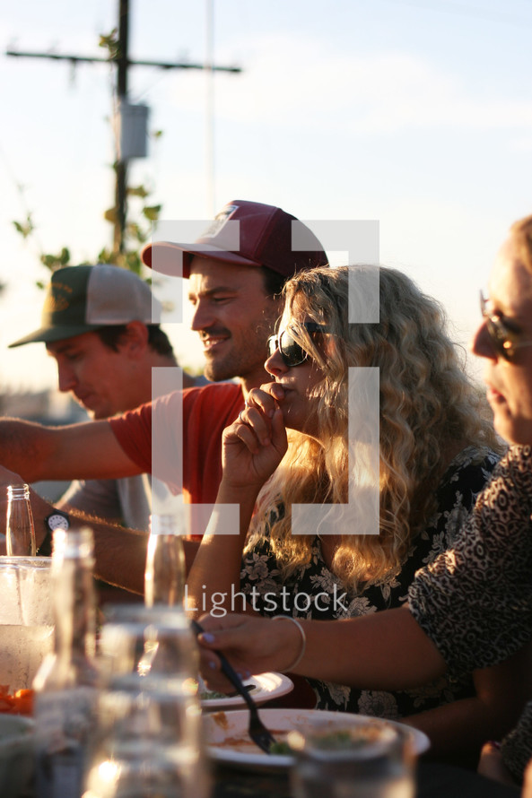 friends eating and drinking beer outdoors 