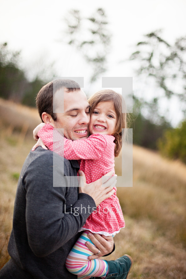 toddler daughter hugging her father tight