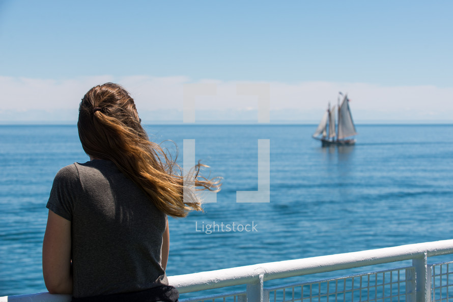 a woman looking over the railing of a cruise ship 