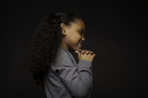 side profile of a girl praying 