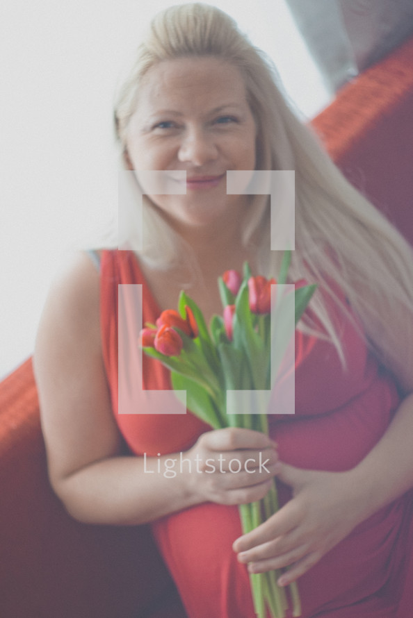 a pregnant woman holding tulips