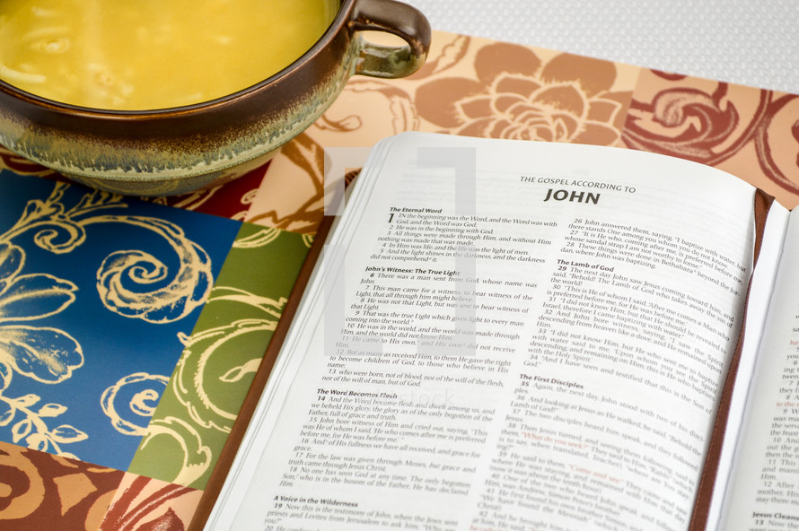 bowl of Chicken Noodle soup and Bible opened to John 