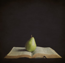 pear resting on the pages of a Bible
