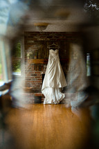 wedding gown hanging over a mantle 