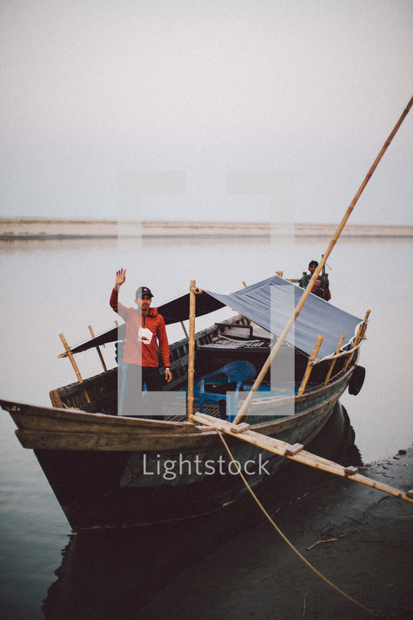 A man waving on a fishing boat 