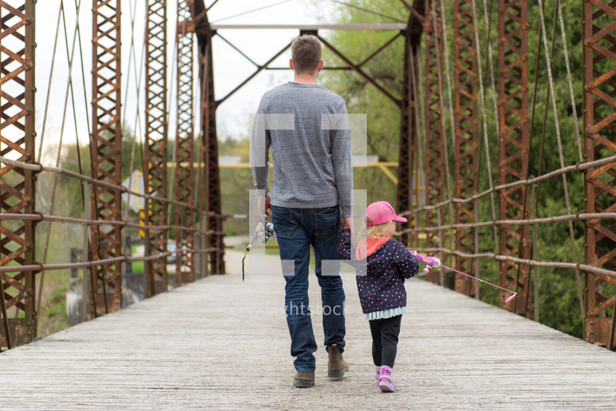 father walking holding hands with his daughter 