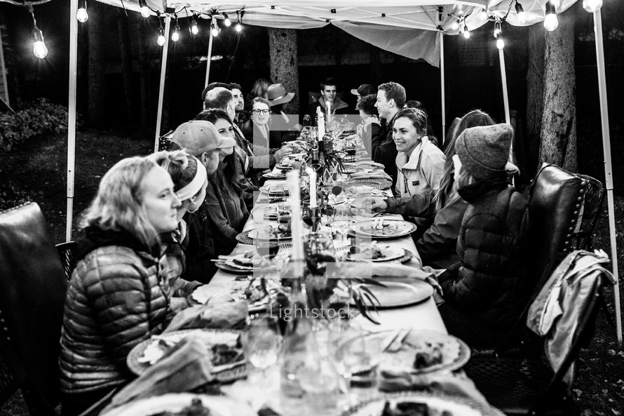Friends gathering at a table to eat - black and white
