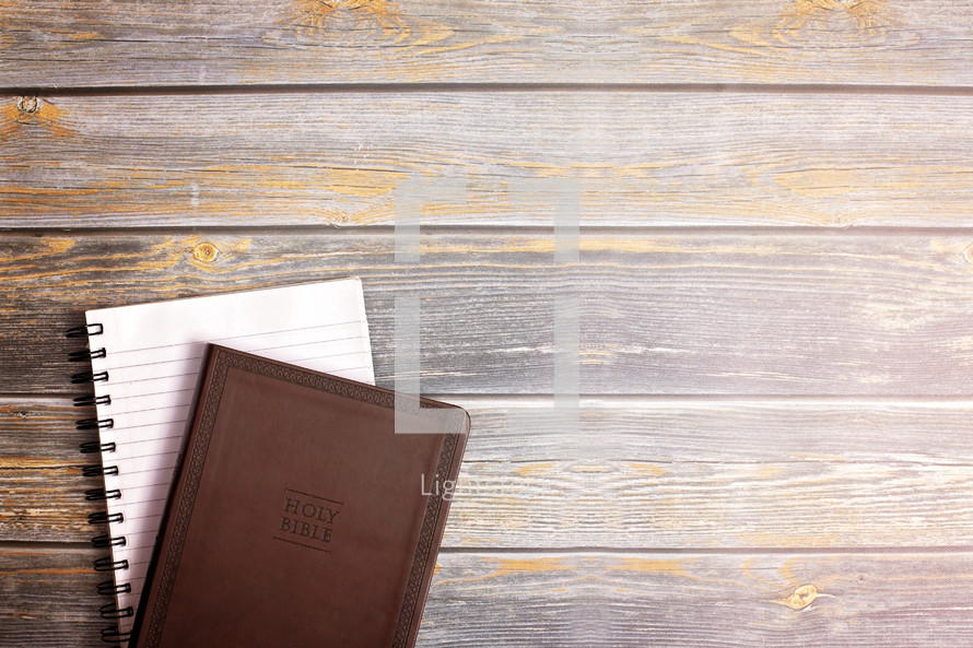 Bible and journal on a wood background 