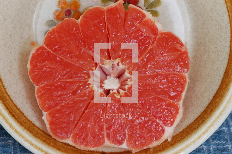Half of a grapefruit on a plate.