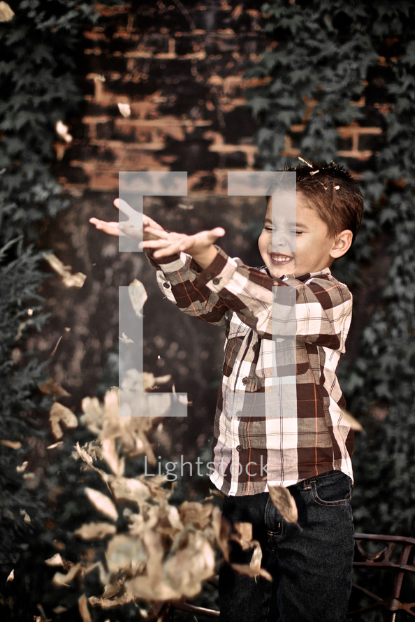 boy child tossing leaves