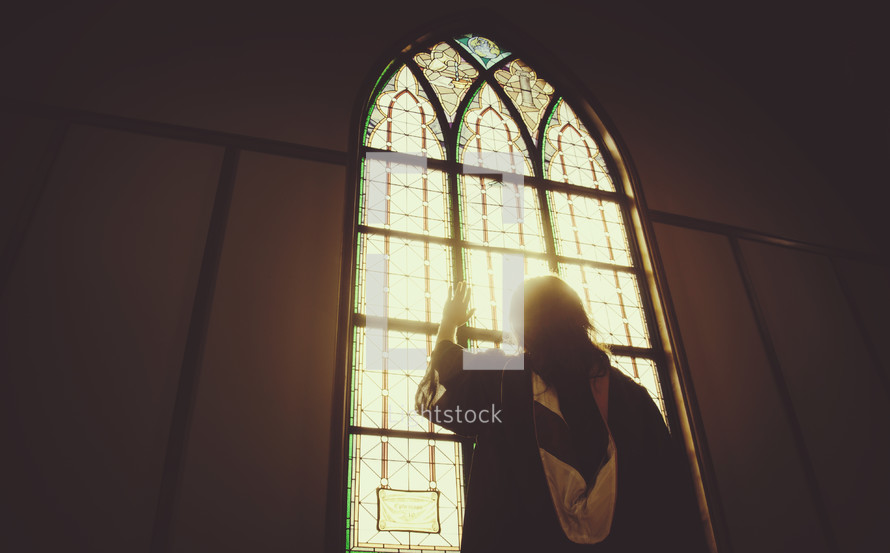 graduate standing in front of a church window