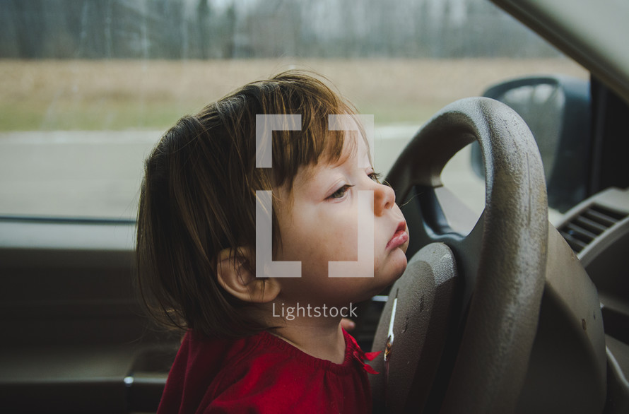 toddler girl at the steering wheel 