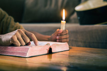 reading a Bible by candlelight 