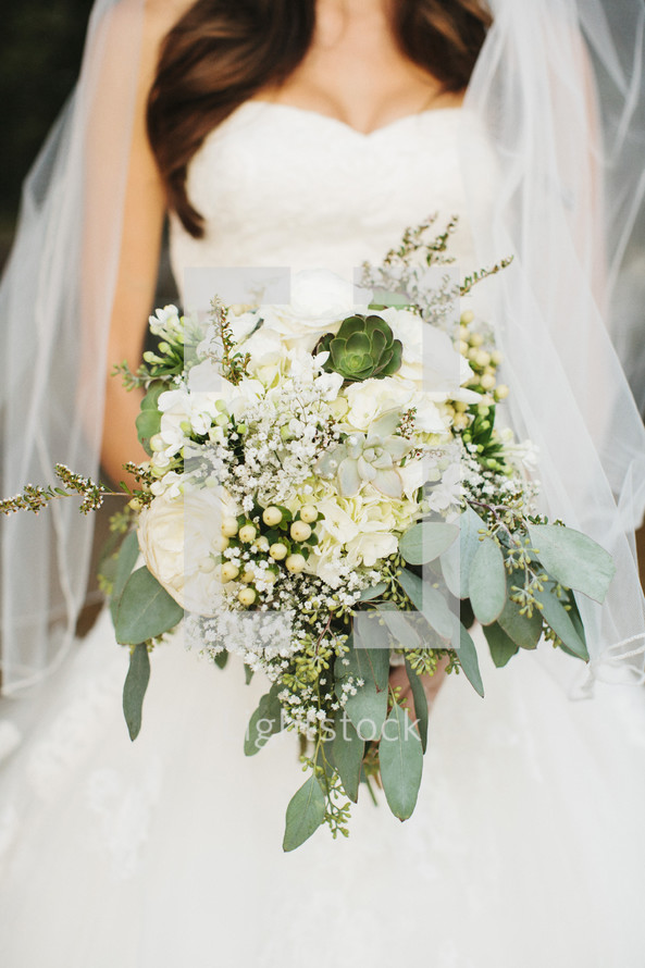 torso of a bride holding her bouquet