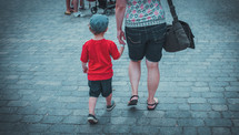 mother and son walking holding hands 