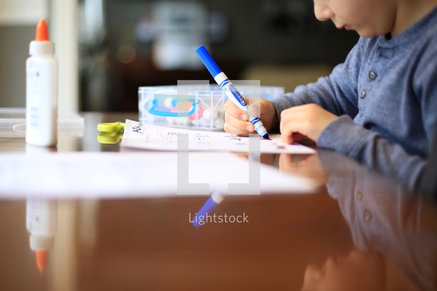 child doing school work with a marker 