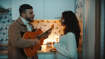 Man playing guitar in the kitchen during breakfast