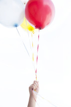 hand holding up balloons