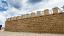 Ancient wall with merlons and sky with clouds background 