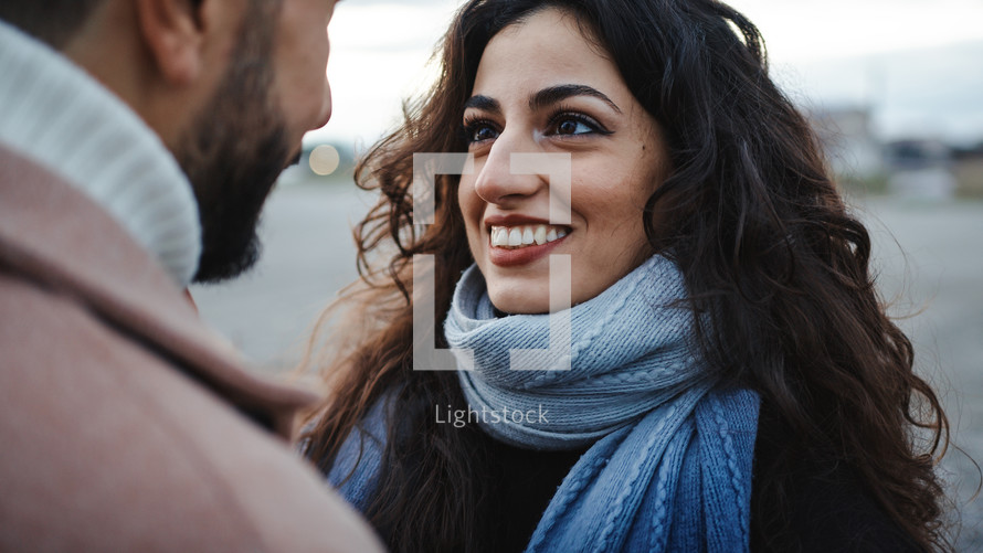 Woman smiling as she hugs a man