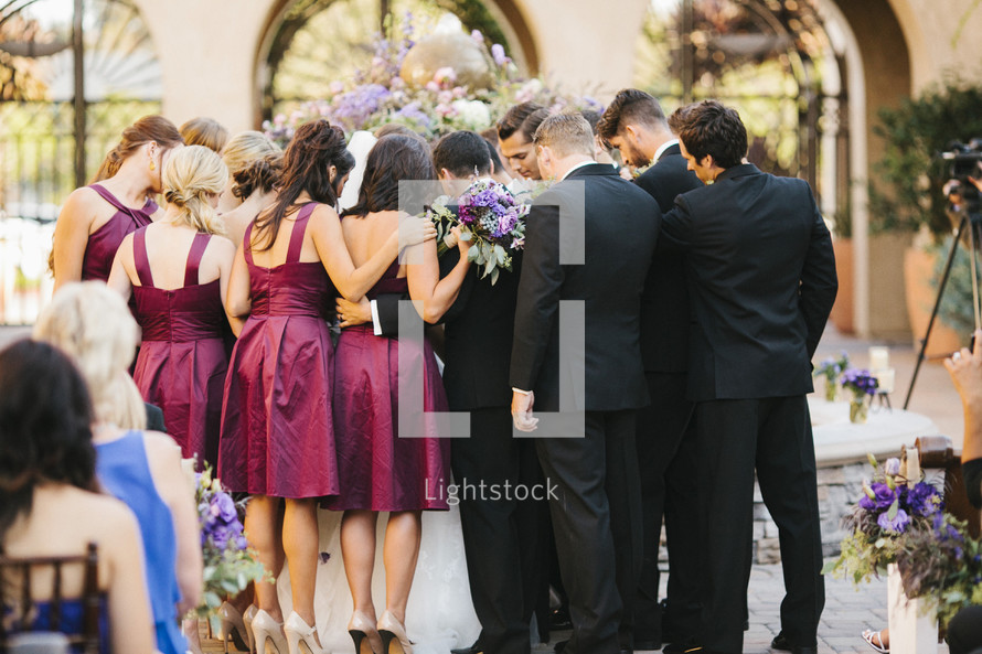 wedding party gathered in prayer