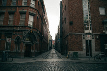 alley between two brick buildings 