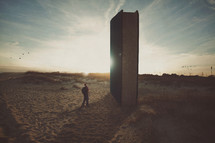 man on a beach looking at a giant Bible 