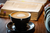 heart shape creamer in coffee and person reading a Bible 