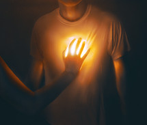 Man with hand over his glowing heart