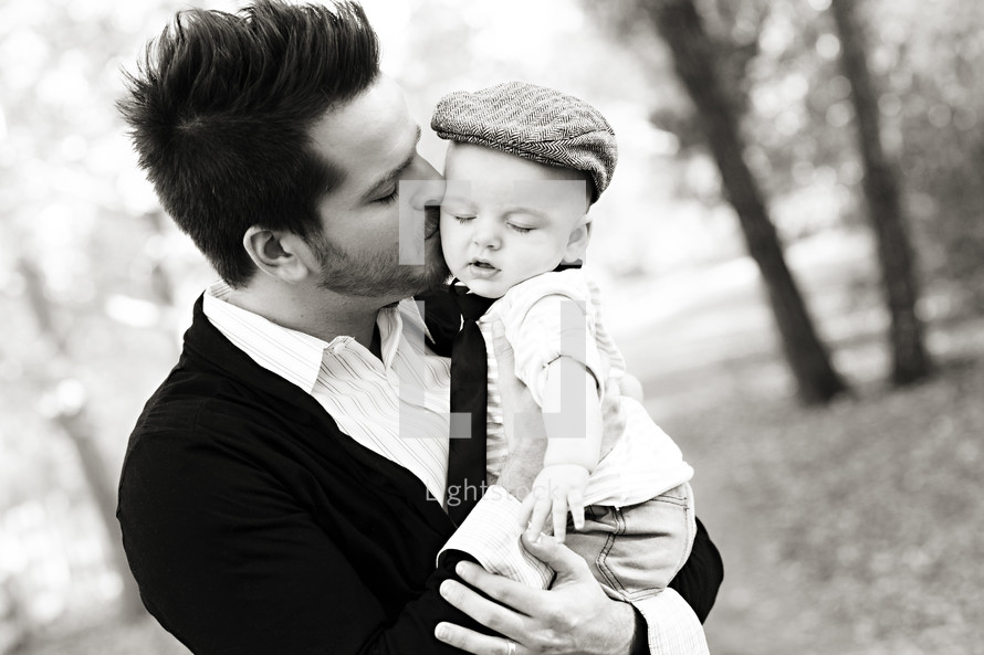 father kissing his infant son