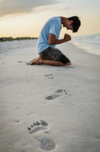 man in prayer on a beach