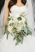 torso of a bride holding her bouquet